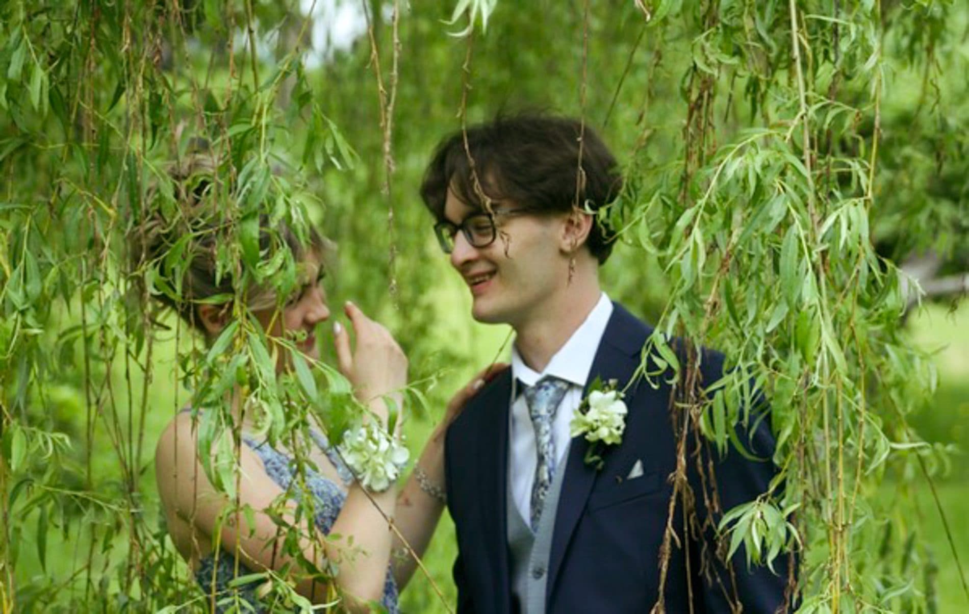 A prom date laughing beneath willow branches